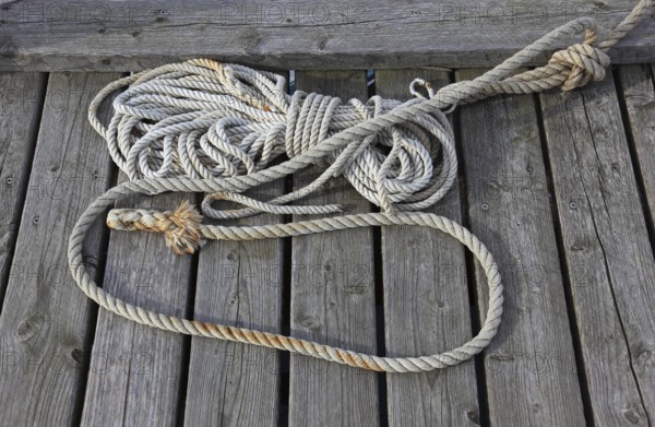A twisted rope is lying on wooden planks, harbor
