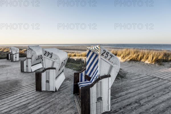 Beach chairs in the dunes and blue sky in winter, sunset, Spiekeroog, East Frisian Islands, Lower Saxony, Germany