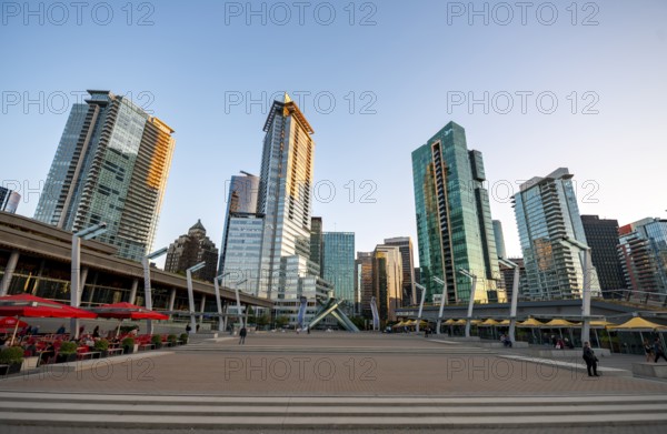 Olympic Cauldron Statue, Jack Poole Plaza Square, skyscrapers on the promenade at sunset, Coal Harbour, Vancouver, British Columbia, Canada