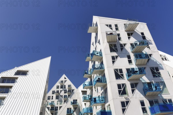 Distinctive white residential complex, turquoise balconies against blue sky, pyramid-shaped buildings, Isbjerget, iceberg, modern architecture in the harbor, Aarhus, Jutland, Denmark