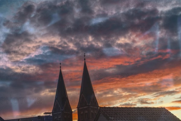 Church towers against dramatic evening sky at sunset, Nettetal