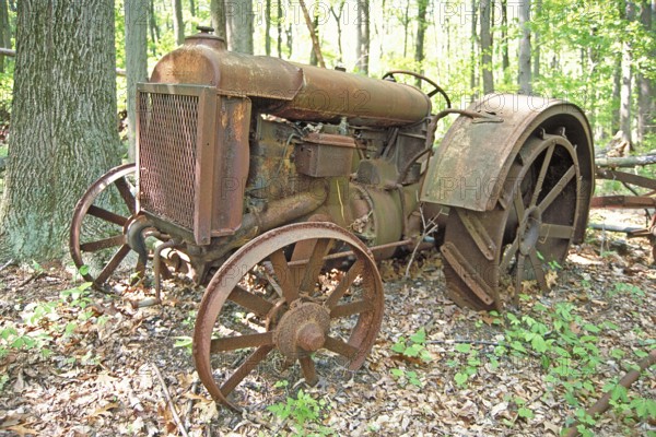 Rusted American Fordson tractor with iron tires around 1900, deposited in a wooded area, Marksboro, New Jersey, USA