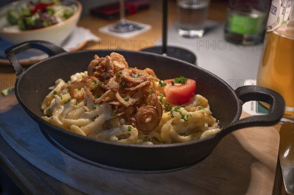 Cheese spaetzle served with roasted onions in a pan, Franconia, Bavaria, Germany