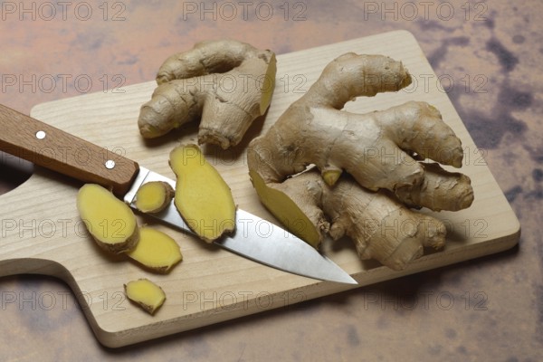 Ginger, ginger root cut with ginger slices on wooden boards