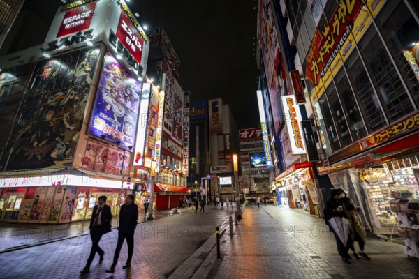 Street with illuminated shops and neon signs at night in Akihabara, Electric City, Tokyo, Japan