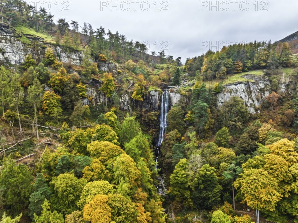 Autumn colours over Pistyll Rhaeadr Waterfall and Berwyn Mountains from a drone, Oswestry, Shrewsbury, Wales, England, United Kingdom