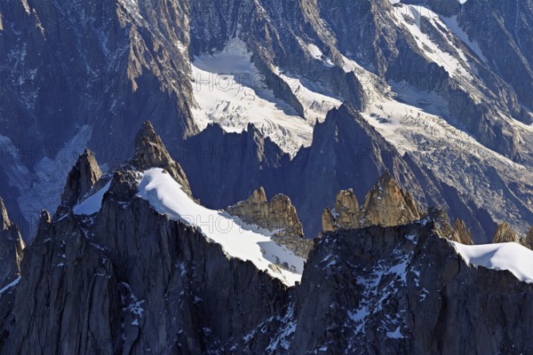 Rugged rocks jut out of a snow-covered mountain, viewing platform, Aiguille du Midi mountain station, Chamonix-Mont-Blanc, Haute-Savoie, France