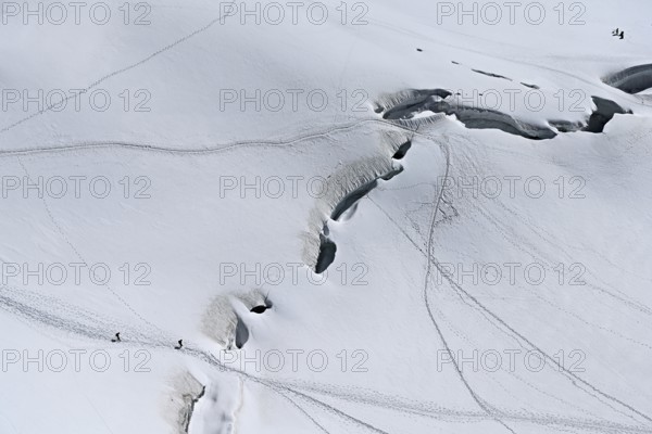 A group of mountaineers runs across a snow-covered mountain, Aiguille du Midi, Chamonix-Mont-Blanc, Haute-Savoie, France