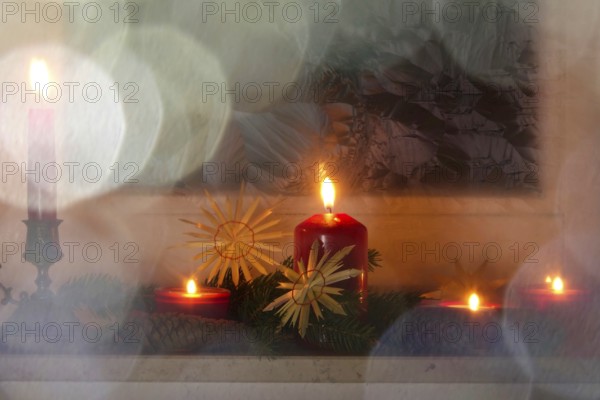 Christmassy decorated iced window, candle light, straw stars, Germany