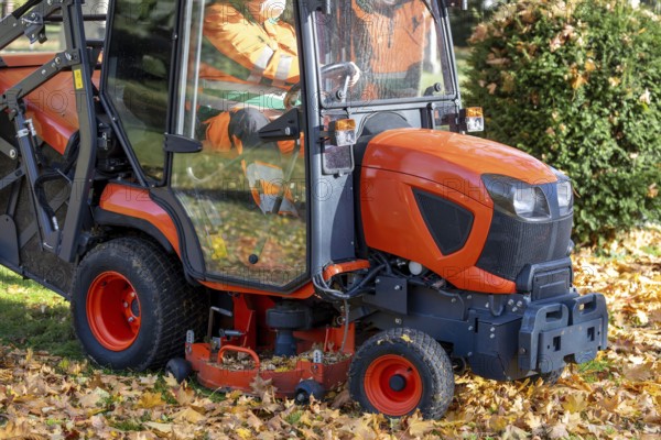 Removing leaves with a riding mower in a public park, Mutterstadt, Rheinland Pfalz