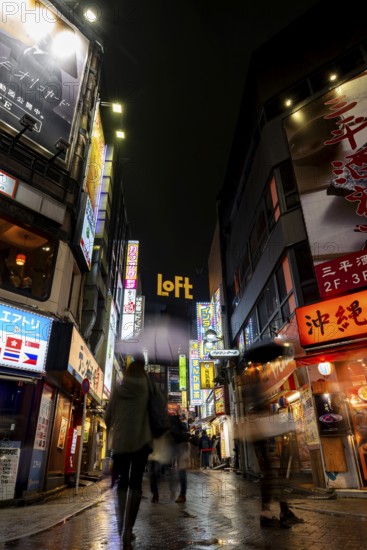 Busy pedestrian zone with many shopping centers and stores, illuminated with lots of neon signs at night, Shibuya, Udagawacho, Tokyo, Japan