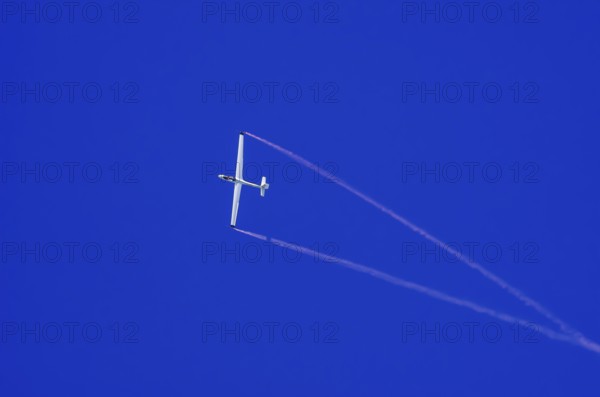 An SZD-59-1 ACRO glider, registration D-1138, during a demonstration as part of an air show at the Fliegerbergfest of the Rossfeld Luftsportverein in Metzingen-Glems, Baden-Württemberg, Germany, for editorial use only