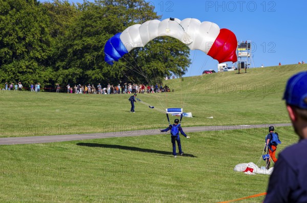 Landing of skydivers during an aerial acrobatic performance as part of an air show at the Rossfeld Air Sports Association Air Sports Festival on Rossfeld in Metzingen-Glems, Baden-Württemberg, Germany, for editorial use only