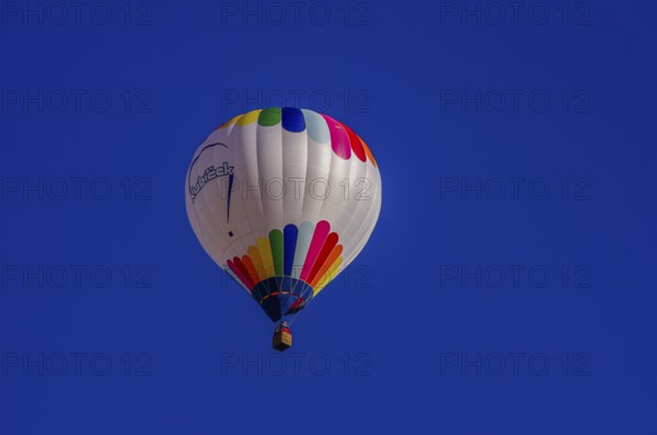 A hot air balloon, registration D-OÖJ, rises into the air as part of an air show at the Fliegerbergfest of the Rossfeld Luftsportverein in Metzingen-Glems, Baden-Württemberg, Germany, for editorial use only