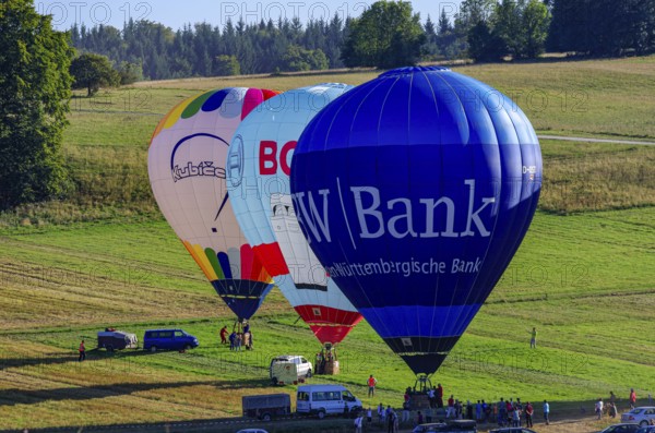 Hot air balloons are being prepared for takeoff as part of an air show at the Fliegerbergfest of the Rossfeld Luftsportverein in Metzingen-Glems, Baden-Württemberg, Germany, for editorial use only