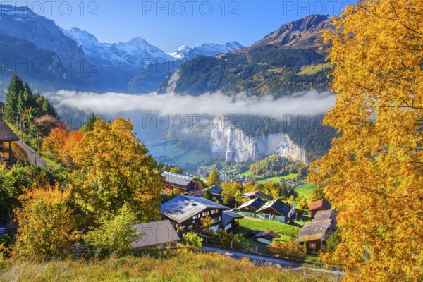 View from the village of the Lauterbrunnen Valley with Staubbach waterfall in autumn with morning fog, Wengen, Bernese Oberland, Canton of Bern, Switzerland
