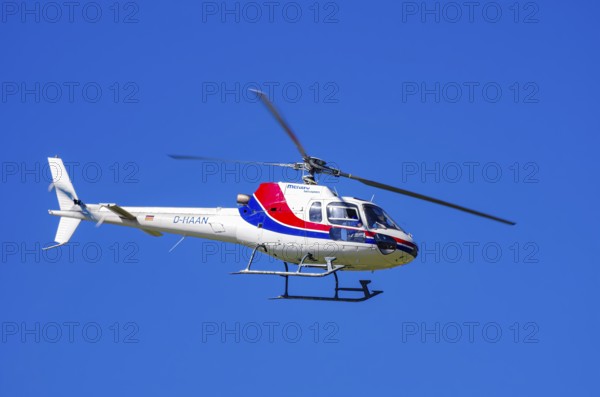 An Aerospatiale AS-350 BA Ecureuil helicopter, registration D-HAAN, from Meravo Air Company during a flight demonstration as part of an air show on Rossfeld in Metzingen-Glems, Baden-Württemberg, Germany, for editorial use only