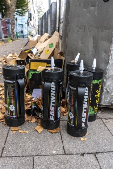 Empty cartridges filled with N2O, nitrous oxide gas, called laughing gas, officially it serves as a propellant to produce whipped cream in appropriate devices, but is often used as an intoxicant, party drug, misused, here mass, illegal disposal in addition to waste paper containers in Düsseldorf, North Rhine-Westphalia, Germany