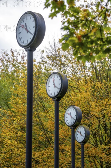 The art installation Zeitfeld in Volksgarten Park in Düsseldorf-Oberbilk, a total of 24 station clocks, on 6 meter high steel columns, have been running synchronously since 1987, artwork by Düsseldorf artist Klaus Rinke, symbol of time, time change, North Rhine-Westphalia, Germany