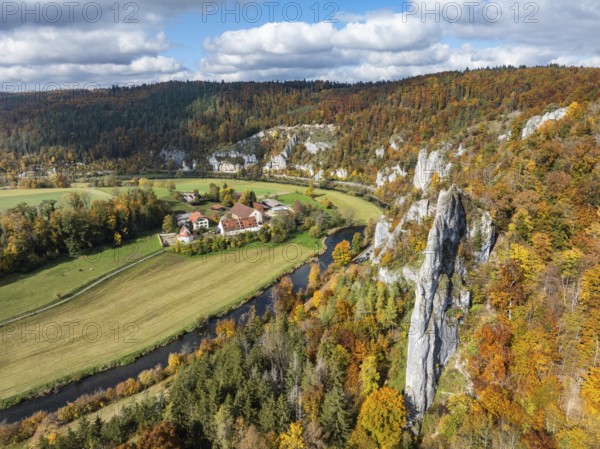Aerial view of Käppeler Manor with St. George's Basilica near Thiergarten in the Upper Danube Valley, surrounded by autumn vegetation, on the right the raven rocks, climbing rocks, Jura limestone rocks, Sigmaringen district, Baden-Württemberg, Germany