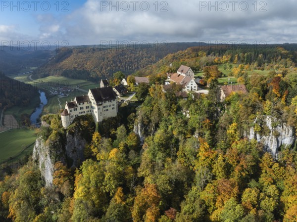 Aerial view of Werenwag Castle and former Werenwag Castle on a rocky spur in the Upper Danube Valley, surrounded by autumnal vegetation and clouds of fog, Sigmaringen district, Baden-Württemberg, Germany