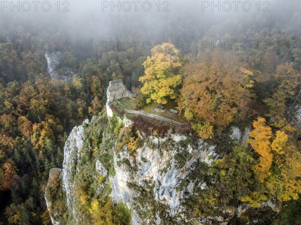 Aerial view of the viewpoint, shovels and Hausen Castle, also known as the Hausen ruins, surrounded by autumnal vegetation and clouds of fog, a ruin of a castle above the village of Hausen in the valley in the Upper Danube Valley, Beuron, Sigmaringen district, Baden-Württemberg, Germany