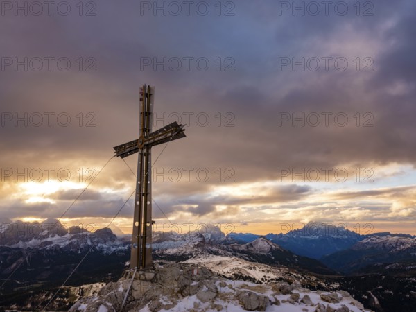 Sassongher summit cross at sunrise, in the background Monte Cristallo, Monte Pelmo and Civatta, Dolomites, Trentino, South Tyrol, Italy