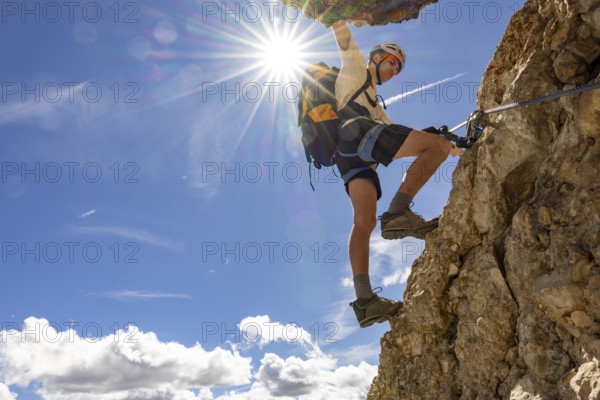 Mountaineer climbs on Ferrata Furcela de Saslonch, Langkofelscharte via ferrata, Dolomites, Trentino, South Tyrol, Italy