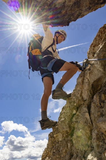 Mountaineer climbs on Ferrata Furcela de Saslonch, Langkofelscharte via ferrata, Dolomites, Trentino, South Tyrol, Italy