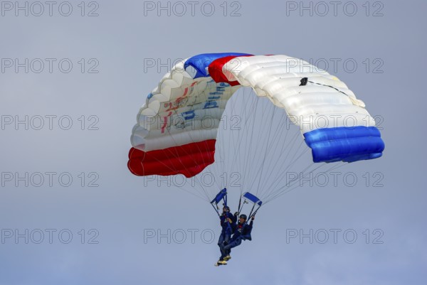Two parachutists during an aerial acrobatic performance as part of an air show at the Rossfeld in Metzingen-Glems, Baden-Württemberg, Germany, for editorial use only