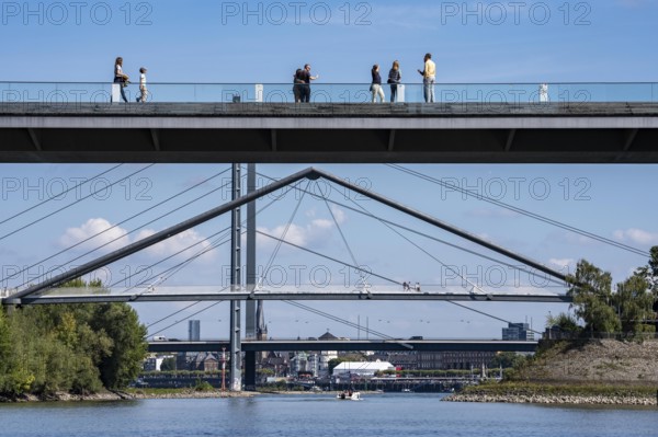 Bridges in Düsseldorf, in the foreground, the pedestrian and cycle bridge over the canal to the inner harbour, media harbour of Düsseldorf, behind it the Rheinkniebrücke, road bridge over the Rhine near Düsseldorf, Germany