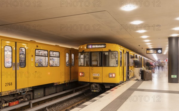 Dynamic scene of a Berlin underground in typical yellow colour, long exposure with blur effect, busy traffic junction at Unter den Linden station, Berlin, Germany