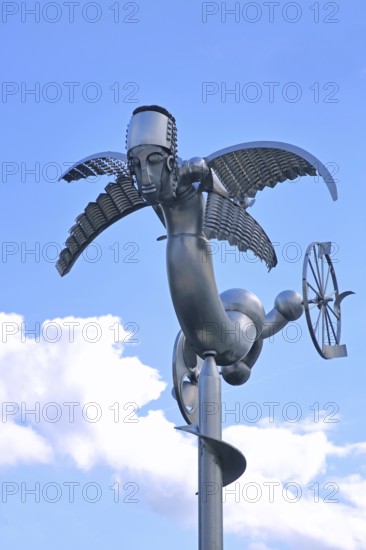 Sculpture Birdman by Albert Sous, modern art, abstract art, stainless steel, metal sculpture, whimsical bizarre bird figure, mythical creature, hybrid creature, wings, flying, wheel, cut-out, detail, Bastinsweiher, Rhineland, Stolberg, North Rhine-Westphalia, Germany