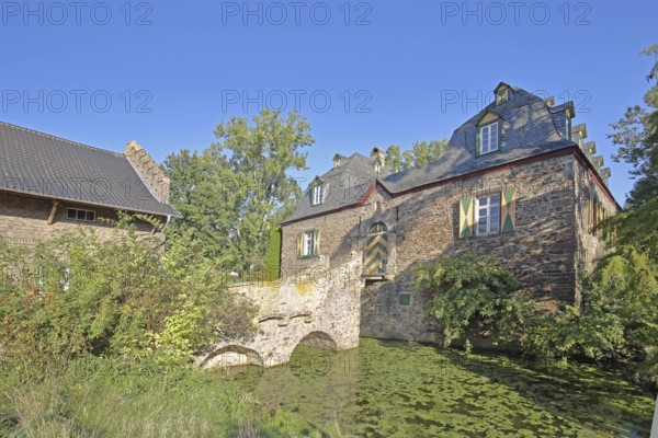 Manor house with stone arch bridge in the inner courtyard of the Kleeburg castle built in the 14th century, moated castle, moat, pond, Weidesheim, Euskirchen, Vordereifel, Eifel, North Rhine-Westphalia, Germany