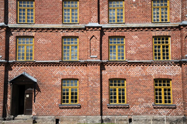 Brick façade with yellow windows, former paper factory and mill for the production of groundwood pulp board, UNESCO World Heritage Site Factory Village Verla, Maailmanperintökohde Verlan puuhiomo ja pahvitehdas, Verla Rapids, Kymenlaakso, near Kouvola, Finland