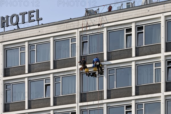 Two male glass cleaners abseiling down the hotel façade to clean windows, aletto Hotel Kudamm, Berlin, Germany
