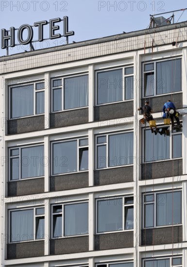 Two male glass cleaners abseiling down the hotel façade to clean windows, aletto Hotel Kudamm, Berlin, Germany