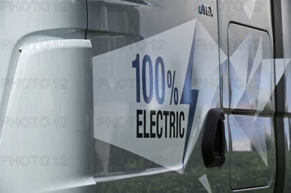 A sign on an electric lorry states that the vehicle is 100 percent electrically powered. The vehicle is parked on the premises of the Enegie-Mann company in Westerwald