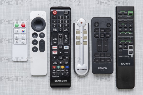 Top shot of a series of remote controls on a white Resopal panel