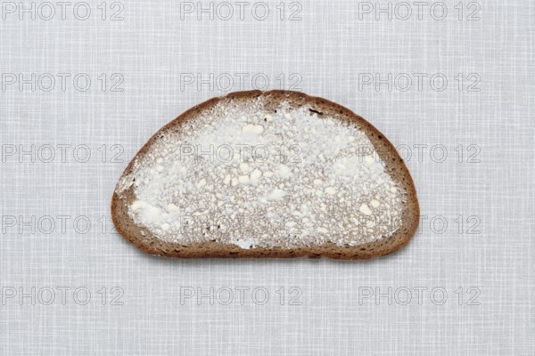 Top shot of a slice of bread smeared with margarine on a white Resopal plate