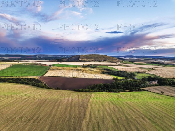 Sunset of Fields and Farms over Traprain Law and Hailes Castle from a drone, River Tyne, Haddington, East Lothian, Scotland, UK