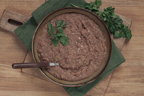 Red bean lobio, a traditional Georgian dish, on a wooden table, homemade