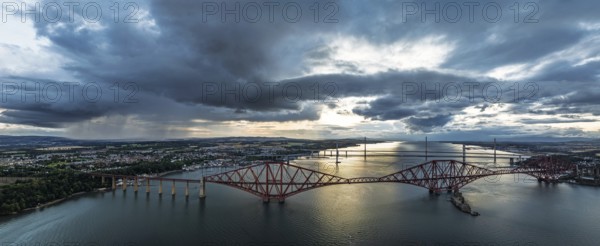 Sunset Panorama of Rain clouds over Forth Bridge from a drone, Queensferry Crossing, Forth Estuary, Scotland, United Kingdom