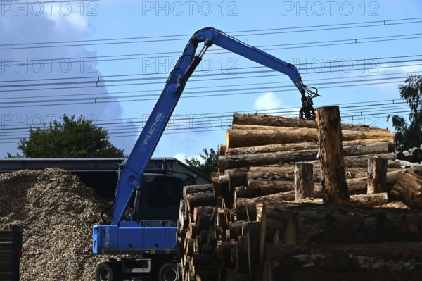Wood storage and mechanical log transport on the premises of Energie-Mann in the Westerwald. Wood pellets are produced there