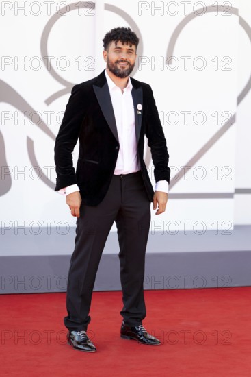 Venice, Italy - 3 September 2025: Amine Bouhafa wears a sticker in the colours of the Palestine flag and a sticker with the inscription - enough - on his jacket during the red carpet of - The Voice Of Hind Rajab - during the 82nd Venice International Film Festival