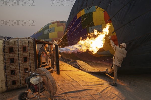 In order to get ready for the take-off, the pilot inflates the balloon with hot air by activating the burner. At dawn. Namib Desert, Kulala Wilderness Reserve, Namibia