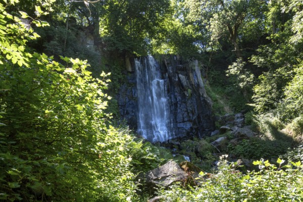 Vaucoux waterfall cascades gracefully over dark rocks, surrounded by lush greenery, Auvergne Volcanoes Regional Park, Puy de Dome., Auvergne-Rhone-Alpes, France