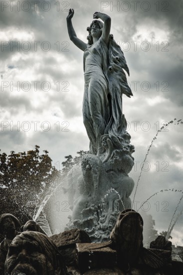 Undine Fountain with dramatic sky in the spa garden Baden, Lower Austria, Austria