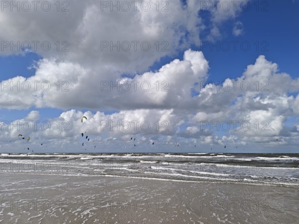 California kitesurfing Masters 2025 on the edge of the UNESCO World Heritage Wadden Sea, North Sea, kitesurfing sport, flying kites, fun, competition, strong wind, high swell, whitecaps, beach, summer, sunshine, blue sky, white clouds, Ording, Sankt Peter-Ording, Schleswig-Holstein, Germany