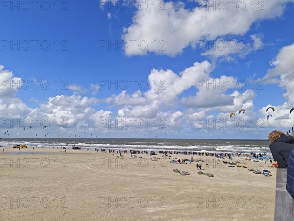 California kitesurfing Masters 2025 at the edge of the UNESCO World Heritage Wadden Sea, North Sea, kitesurfing sport, flying kites, spectators, fun, competition, strong wind, whitecaps, beach, summer, sunshine, blue sky, white clouds, Ording, Sankt Peter-Ording, Schleswig-Holstein, Germany